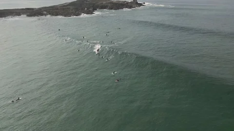 Surfers surf on waves with surfboards at the Pointe de la Torche in Brittany Stock Footage 212341848