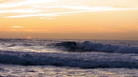 Surfers surfing on waves during sunset Stock Footage 71542690