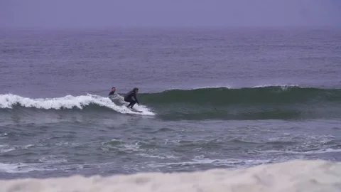 Surfers surfing on waves in slow motion Stock Footage 71564258