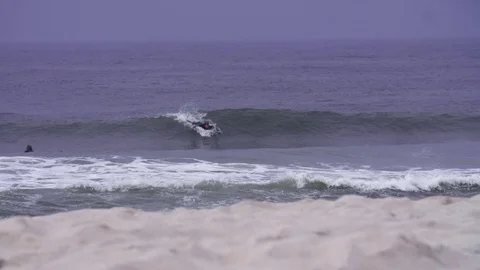 Surfers surfing on waves in slow motion Stock Footage 71564548