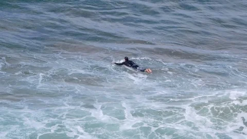 Surfers swims layed on his table against the waves Stock Footage 89570105