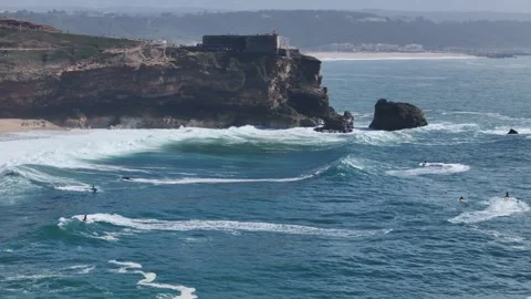 Surfers tackle massive waves in Nazare, Portugal during epic winter swell Stock Footage 287731389
