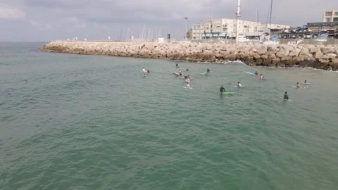 Surfers wait in the water and catch small waves Stock Footage 228064298