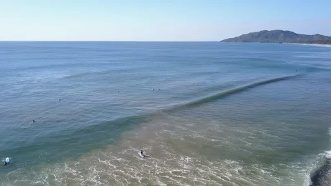 Surfers waiting in lineup while SUP paddles out and falls Playa Grande Stock Footage 90971142