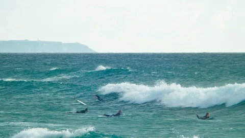 Surfers waiting for the proper wave in the ocean 4k Stock Footage 85563551