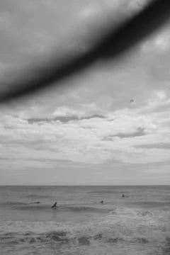 Surfers Waiting for Waves Under a Cloudy Sky Foto stock