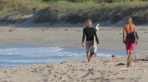 Surfers walking at the beach Stock Footage 26322686