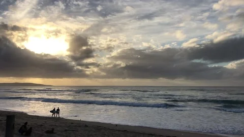 Surfers walking on beach at sunrise Stock Footage 168361803