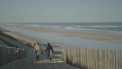Surfers walking down path to the sea 库存影片 345717666