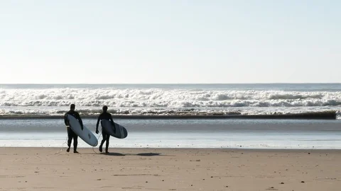 Surfers Walking Out To Ocean Waves Stock Footage 120213319