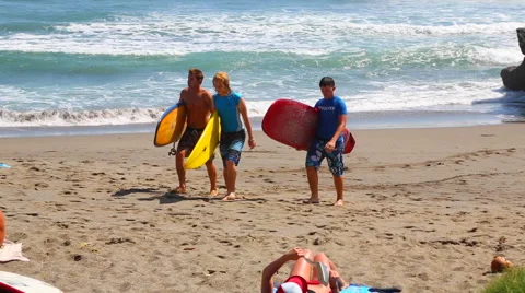 Surfers Walking up the Sand Stock Footage 50447858