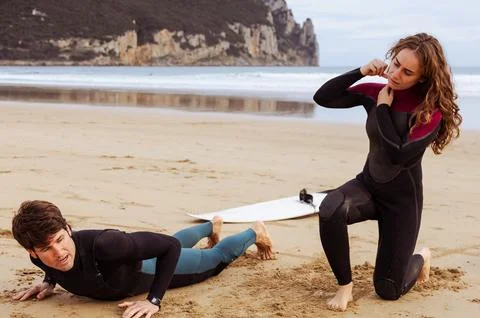 Surfers warming up on the beach before hitting the waves Stock Photos