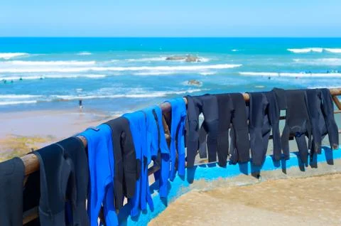 Surfers wetsuits drying on beach Stock Photos