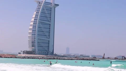 Surfing in Dubai with Burj al Arab Jumeirah in the background Stock Footage