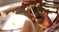 Surfing Internet with Mobile Phone in a Cafe. HD Footage