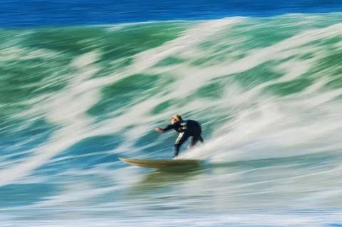 Surfing a steep wave with dynamic blurred motion Stock Photos