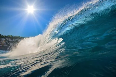 Surfing wave. Blue ocean crest. Sea water with sun over blue sky on backround Stock Photos