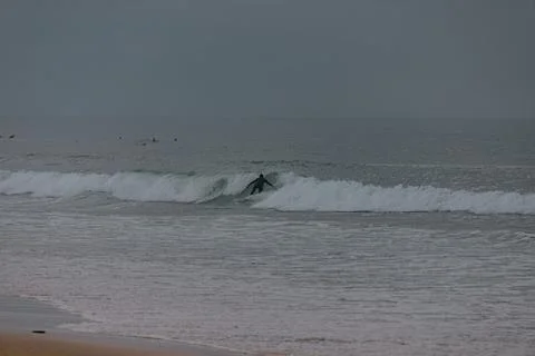 Surfing the waves on a cloudy day 스톡 사진
