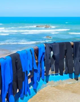 Surfing wetsuits drying on beach Stock Photos