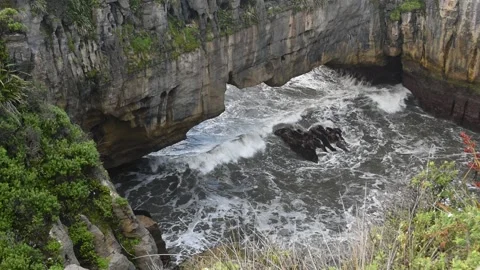 Surge pool with the sea rolling in under a natural arch, New Zealand. Video stock 146990108
