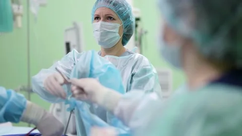 The surgeon and the assistant look at the screen showing the operated organ. A Видео 172465396