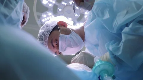 A surgeon and an assistant perform an operation on a patient. Sew a wound. Stock-Footage 124402875