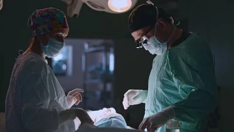 Surgeon and an assistant perform an operation Stock Footage 174128372