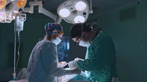 Surgeon and an assistant perform an operation Stock Footage 174128975