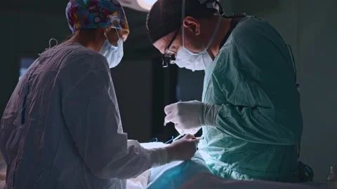 Surgeon and an assistant perform an operation Stock Footage 174129048