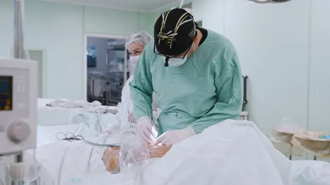 Surgeon and an assistant perform an operation Stock Footage 174130009