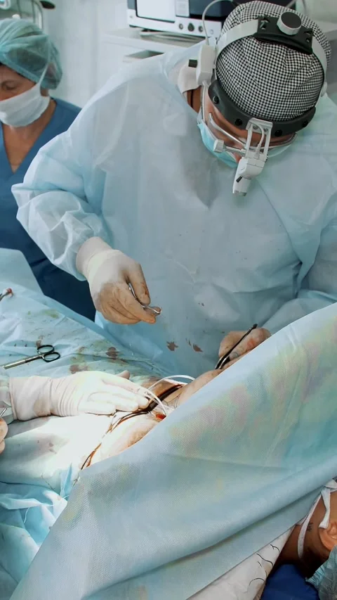 The surgeon and his assistant suture the incisions under the mammary glands Stock Footage 316891270