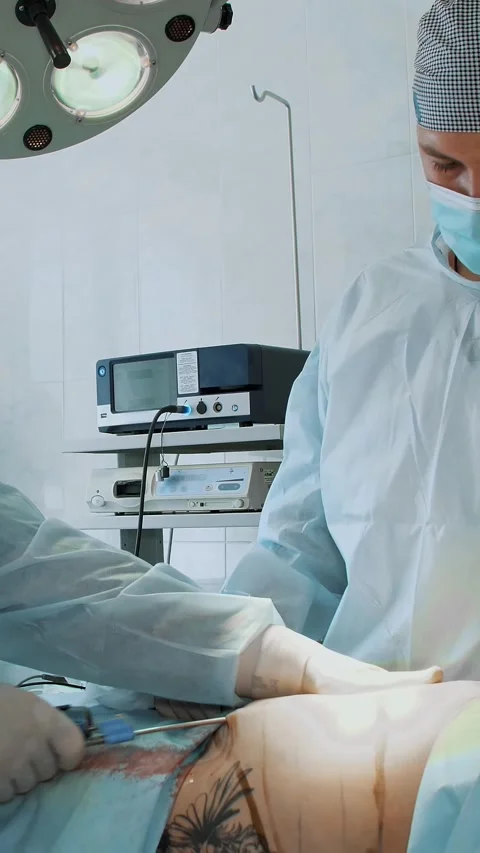 The surgeon and his assistant suture the incisions under the mammary glands Stock Footage 318725421