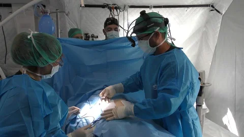 Surgeon and operating room nurses dressing an injured person before surgery Vidéo 116788266