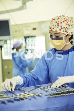 Surgeon Arranging Surgical Scissors On Tray In Operating Room