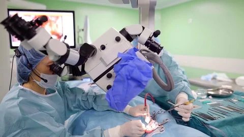 Surgeon with an assistant in a process of cochlear implant surgery. Stockbeeldmateriaal 98363675