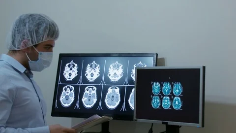 Surgeon Compare Head Scans and Taking Notes Stock Footage 71381783