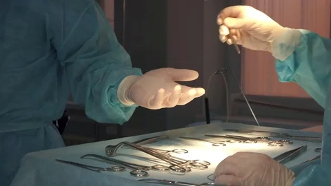 The surgeon is given medical instruments during the operation, a close-up Stock Footage 84774465