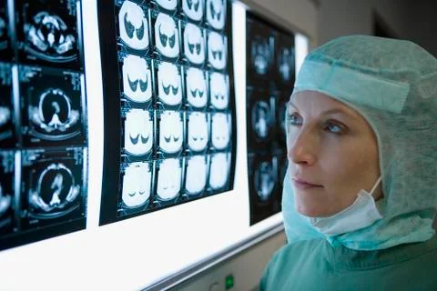 A surgeon looking at a lightbox with x-rays Stock Photos
