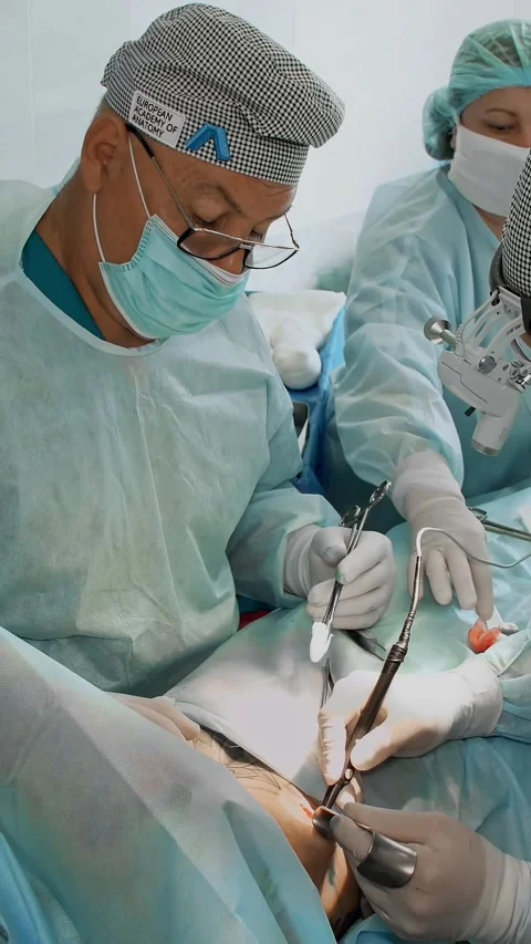 Surgeon makes an incision under breast using a laser to female patient. He is Stock Footage 318462628