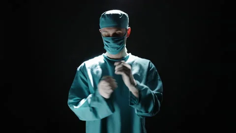 Surgeon man taking on protective gloves while posing over isolated background. Stock Footage 175239647