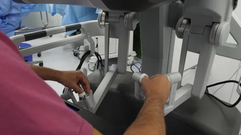 The surgeon moves the arms of the Robot through computer commands. Stock Footage 292062863