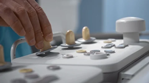 Surgeon operates robotic diagnostic system via remote control panel, close-up Stock Footage 119653114