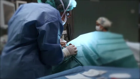 Surgeon operating patient in operating room. Stock Footage 100559342