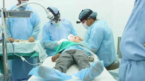 Surgeon operating on a patient's eye and his staff assisting him Stock Footage 77447144