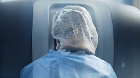 Surgeon operating at the robotic console in operations room using robotic arm 動画素材 102187211