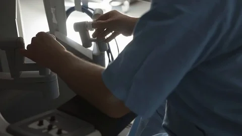 Surgeon operating robotic surgery machine, Minimally Invasive Da Vinci System Stock Footage 89582895