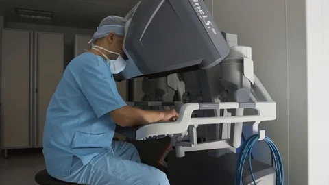 Surgeon operating robotic surgery machine, Minimally Invasive Da Vinci System Stock Footage 89583376