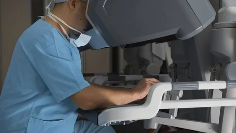 Surgeon operating robotic surgery machine, Minimally Invasive Da Vinci System Vídeos de archivo 89583537