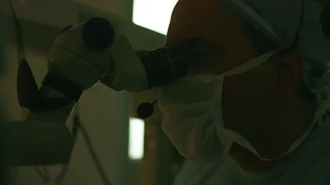 Surgeon peeping through an autorefractor Stock Footage 77447405