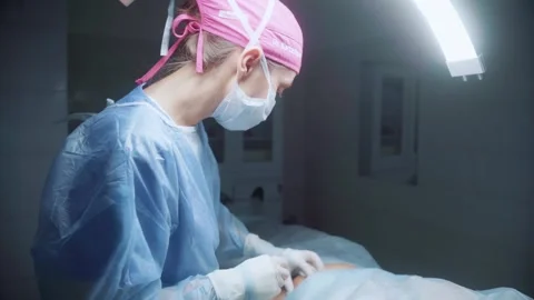 Surgeon performing delicate operation in surgical theater with focused precision Stock Footage 295864353
